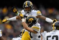 Julius Brents of the Iowa Hawkeyes congratulates teammate Riley Moss on an interception